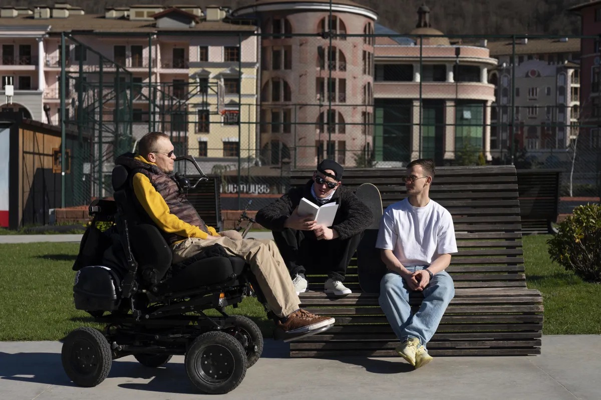 Group of people with special needs sitting outdoors